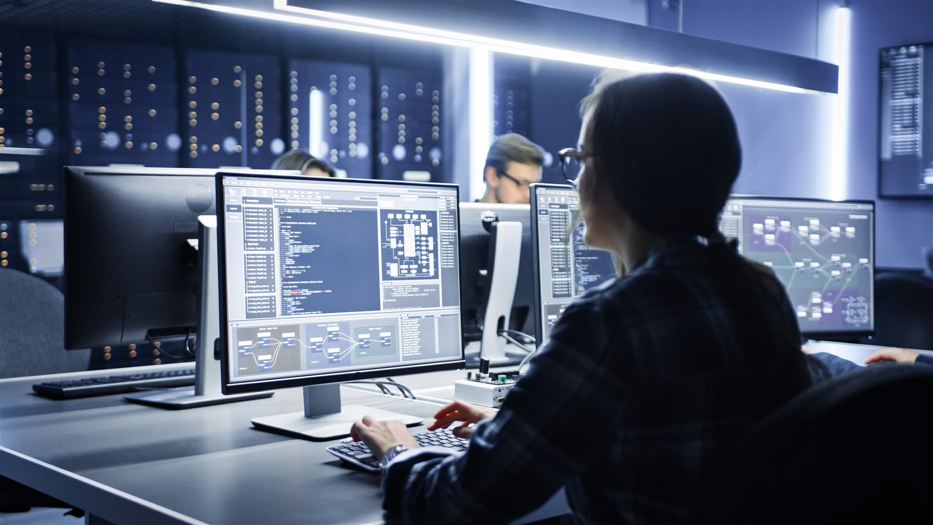 IT specialists working at computer monitors in a network operations center